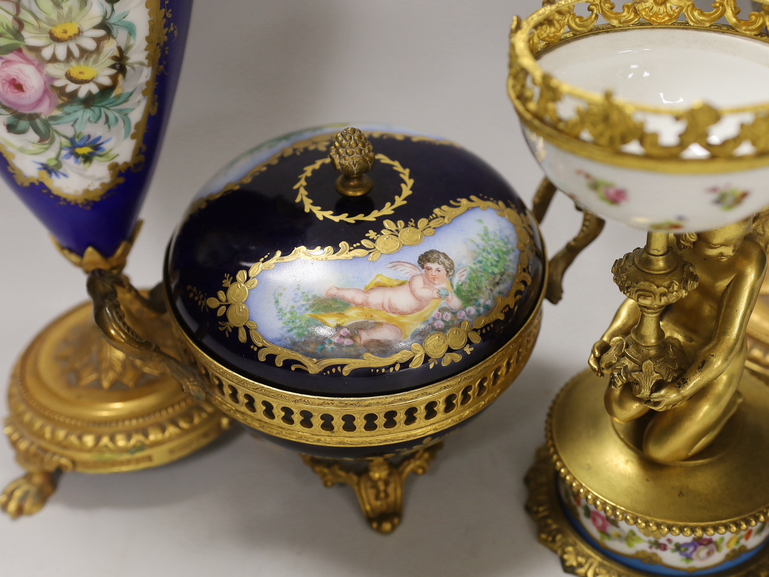 A pair of Sevres style porcelain ormolu mounted vases, a similar putti stemmed cup and a bowl and cover, tallest 27cm